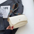 Chic cream white crossbody bag with ethnic patterned wide strap on a grey suit background - Off-white