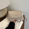 Elegant beige crossbody bag with gold bow clasp in premium leather finish - Khaki