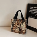 Retro-Jacquard-Canvas-Tasche mit Blumenmustern und schwarzen Griffen auf Marmorfläche - Schwarz Klein