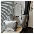 Detalle de bolso tote plateado con relieve de cocodrilo y cartera de mano lisa a juego - Plateado