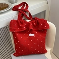 Red floral mesh tote bag with ruffle trim and Magic Pocket label on white chair - Red
