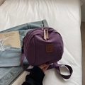Lila kleiner Nylon Rucksack mit verstellbaren Trägern auf weißem Bettlaken Hintergrund - Lila