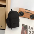 Zwarte mini canvas schoudertas met ritsvak gepresenteerd in een stijlvolle setting - Zwart