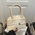 Chic cream white shell crossbody bag featuring elegant buckled strap details and top handles - Off White
