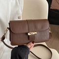 Donkerbruine crossbodytas met krokodillenprint en elegante gouden bamboe sluiting - Bruin
