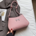 Chic pink faux leather shoulder bag featuring a silver metal bow accent and knotted straps - Pink