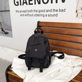 Mochila multiusos negra minimalista con etiqueta de moda sobre un banco de madera - Negro
