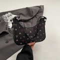 Black half-moon underarm bag with pink floral patterns and silver bow charm detail - Brown