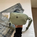 Light green nylon crossbody bag with adjustable strap and circular logo on white bedding - Green