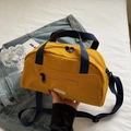 Yellow nylon tote crossbody bag with blue handles on denim background for daily use - Yellow