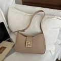 Elegant beige underarm hobo bag with vintage gold metal buckle on white bedding - Khaki