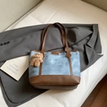 Blaue Denim-Tragetasche mit braunem Lederbesatz und Bären-Anhänger in Lifestyle-Szene - Mit Anhänger / Blau