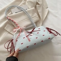 Borsa a tracolla azzurra con fiocchi rossi stampati e ciondolo a cuore in dettaglio - Blu