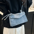 Lichtblauwe gradiënt crossbodytas met touwhandvat getoond op een modemodel - Blauw