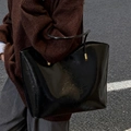 Chic black patent leather tote bag with glossy finish and elegant gold hardware detailing - Black