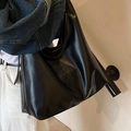 Bolso tote grande negro minimalista en cuero PU brillante llevado al hombro por modelo - Negro