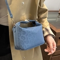 Blaue Umhängetasche mit Leopardenprägung in Matt-Optik und Goldschnalle an einem Modell getragen - Blau