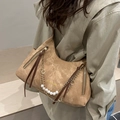 Brown half-moon shoulder bag with decorative pearl chain and tassel zippers on a model - Khaki
