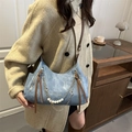 Blue denim and brown leather tote bag with pearl chain detail worn by a model - Blue