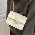 Bolso bandolera de cuero blanco acolchado con hebilla de perla dorada llevado por modelo - Blanco
