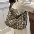 Grande borsa tote in tela con stampa leopardata indossata a spalla da una modella - Cachi