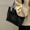 Elegante borsa tote in pelle PU nera con foulard a fantasia portata a spalla da modella - Nero