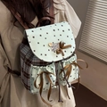 Mochila verde menta con estampado de estrellas, cuadros y lazo llevada por modelo - Verde