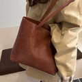 Bolso tote vintage marrón oscuro de piel sintética con correa de hombro mostrado en modelo - Marrón