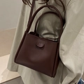 Minimalist dark brown leather bucket bag with lychee pattern and dual round handles - Brown