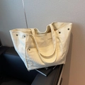 Off-white corduroy tote bag with spacious design and stylish rivet metal accents - White