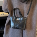 Chic black glossy oil wax leather bucket bag with silver twist lock and crossbody strap - Black