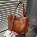 Dark brown faux leather bucket bag with twist lock closure and adjustable strap - Brown