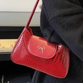 Red crocodile embossed underarm bag featuring a silver metal bow accent in shiny finish - Red