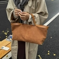 Detalle del bolso tote de ante color caramelo con adornos de cuero y hojas secas - Marrón