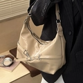 Borsa hobo beige minimalista con fibbia in metallo e catena su modella in completo - Cachi