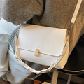 White minimalist crossbody bag with woven handle detail and gold clasp on model - Off-white