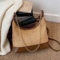 Braune Vintage Wildleder Umhängetasche mit Goldkette auf einer Webmatte - Khaki