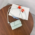Mint green crossbody messenger bag with double buckles and blue chain on wooden table - Green