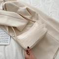Elegante borsa baguette color crema effetto coccodrillo con silhouette a mezza luna - Bianco