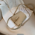 Borsa a secchiello minimalista in pelle beige con fibbia metallica su sedia ufficio - Cachi