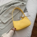 Minimalistische hellgelbe Schultertasche auf einem grünen Blazer-Jackett - Gelb