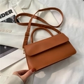 Karamellbraune Lederhandtasche mit verstellbarem Schultergurt und Tragegriff im Studio - Braun