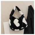 Detalle de bolso de piel sintética con estampado de vaca en blanco y negro y asa suave - Talla única / Negro