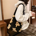 Detail of black fuzzy tote bag featuring brown teddy bear patterns and soft plush texture - Black