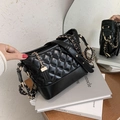 Bolso hobo acolchado negro con cadena dorada sobre una revista de moda - Grande / Negro