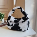Gros plan du sac à main en peluche à motif vache montrant la texture douce - Noir