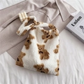 White faux fur tote bag with brown bear patterns on soft autumn winter bedding background - White