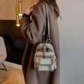 Detail of vintage tartan patterned wool backpack with brown leather straps and metal zipper - Green