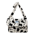 Winter faux fur handbag featuring trendy black and white cow print with a blue label detail - Cow Print
