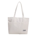 Cabas minimaliste en toile blanche avec poches avant et étiquette noire brodée - Blanc